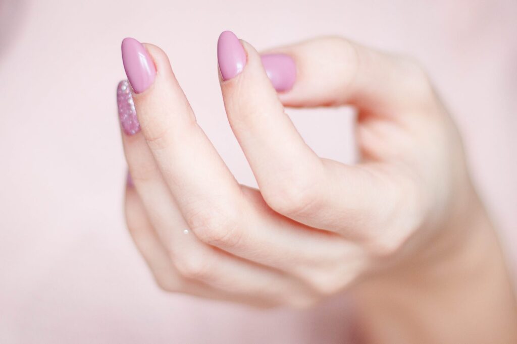 person s hand with pink manicure